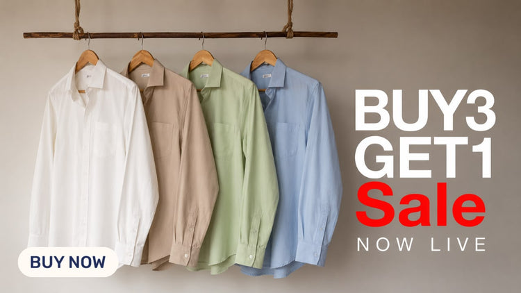 Four long-sleeve button-up shirts in white, beige, sage green, and light blue hang on wooden hangers from a horizontal wooden rod against a warm beige wall. Large promotional text on the right reads 'BUY 3 GET 1 Sale NOW LIVE' with a 'BUY NOW' badge in the bottom left.